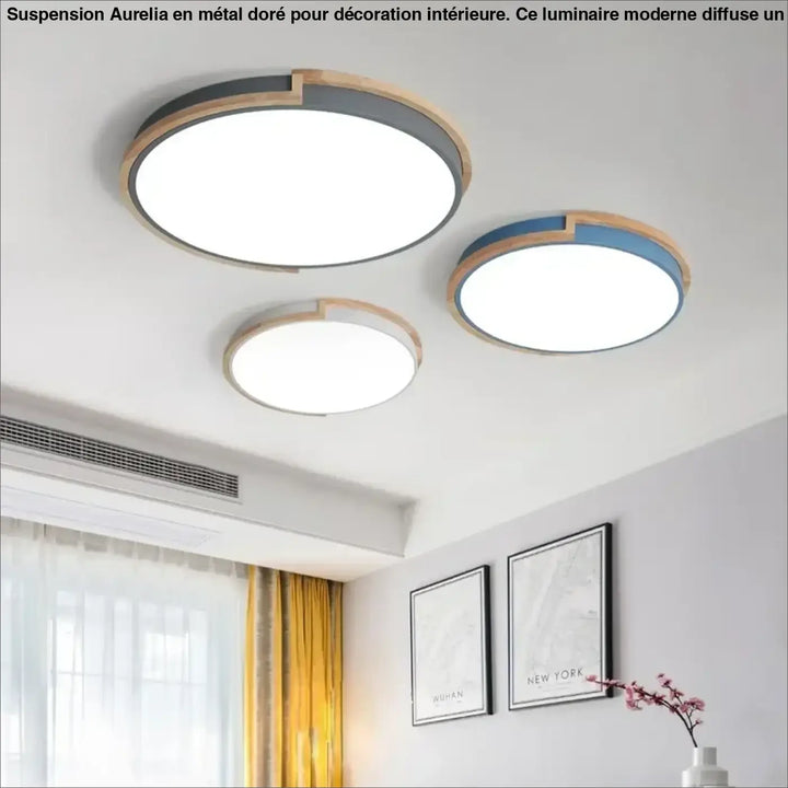 Suspension luminaire aurelia en métal doré avec cadres en bois et métal gris au-dessus d’un coin salon moderne