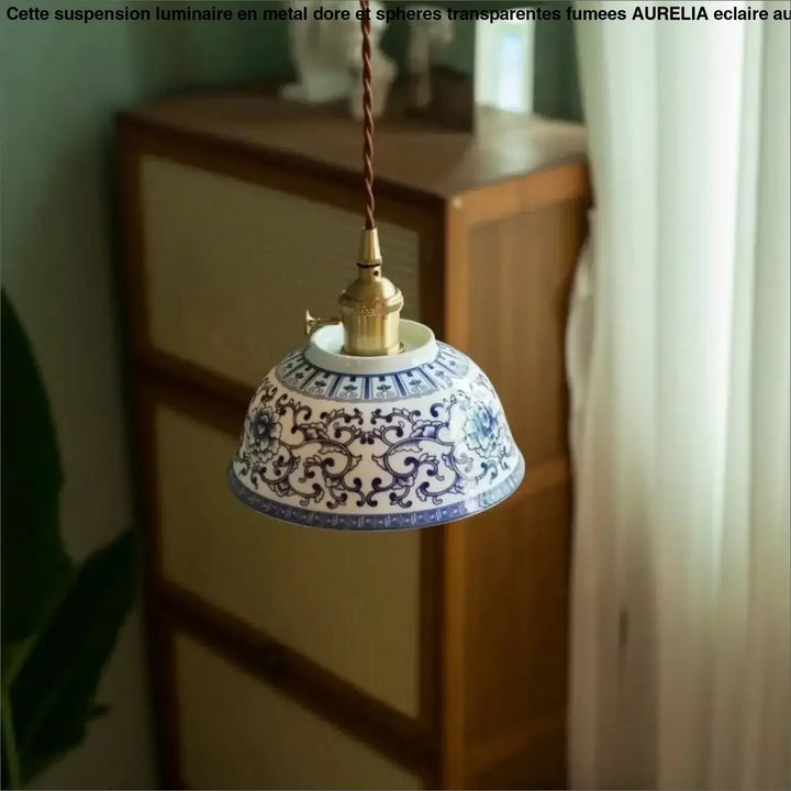 Photos montrent une suspension luminaire nara en porcelaine bleue et blanche avec motifs floraux suspendue par un cordon torsadé