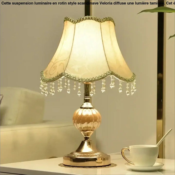 Lampe de table gold ton avec abat-jour en tissu crème à franges en cristal et base métallique ornée pour décoration intérieure vintage chic