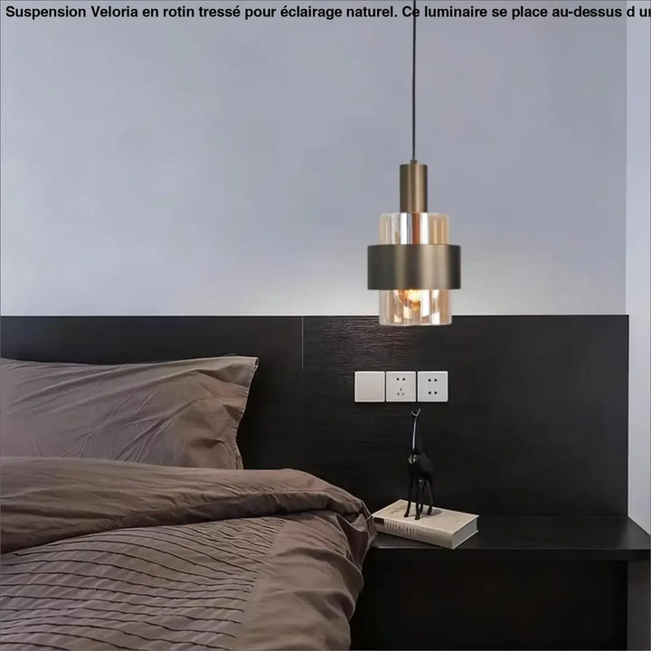 Suspension luminaire veloria en rotin tresse naturel avec abat-jour cylindrique en verre fumé et laiton au-dessus d’un coin salon