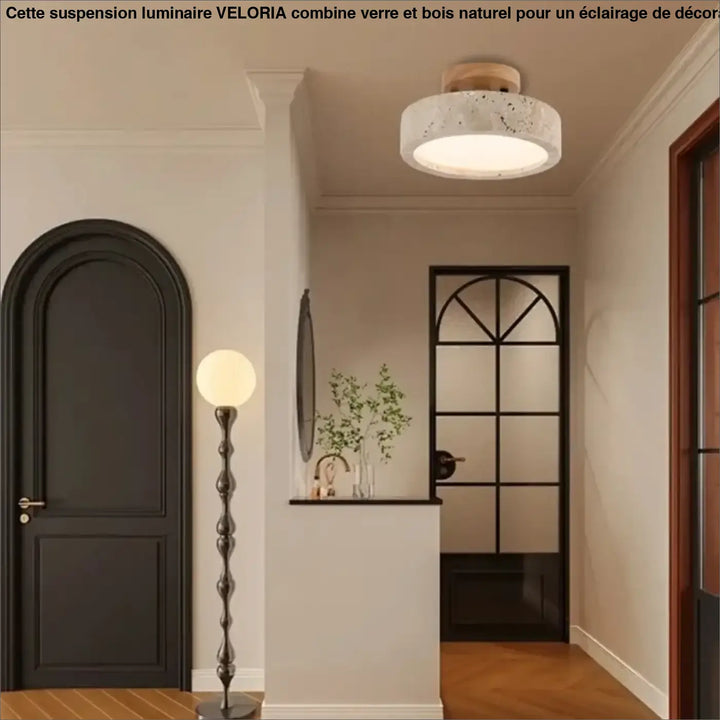 Suspension luminaire en verre avec détails en bois naturel et abat-jour circulaire blanc moucheté en béton au-dessus d’une table