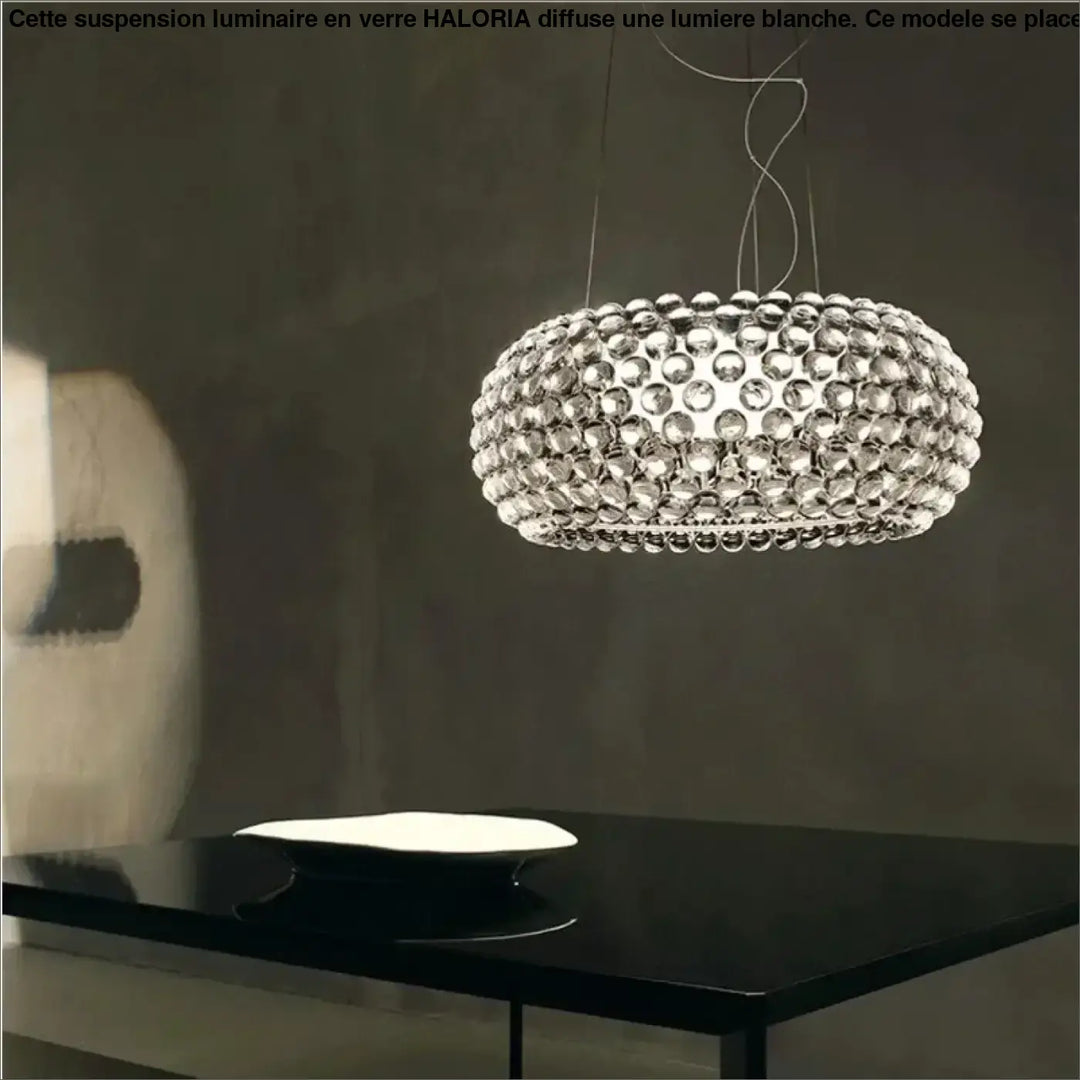 Suspension luminaire en verre avec lumiere blanche composée d’orbes clairs circulaires au-dessus d’une table
