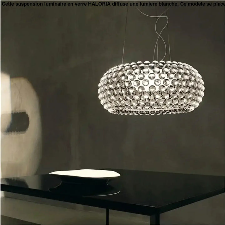 Suspension luminaire en verre avec lumiere blanche composée d’orbes clairs circulaires au-dessus d’une table