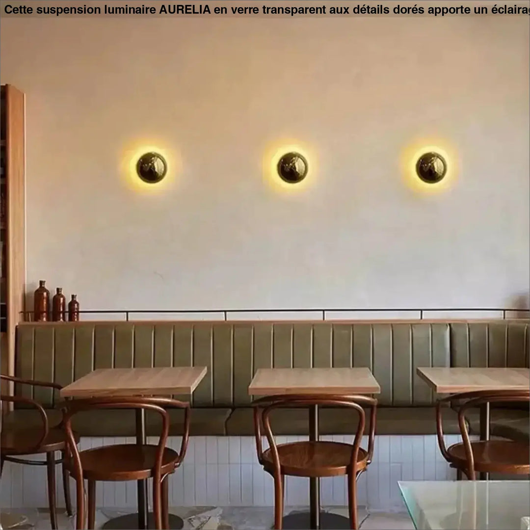 Applique murale orbys en métal miroir finition laiton avec lumière douce et surface texturée pour ambiance chaleureuse