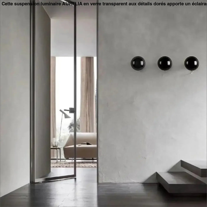 Applique murale orbys en métal miroir avec trois sphères noires brillantes offrant une lumière douce