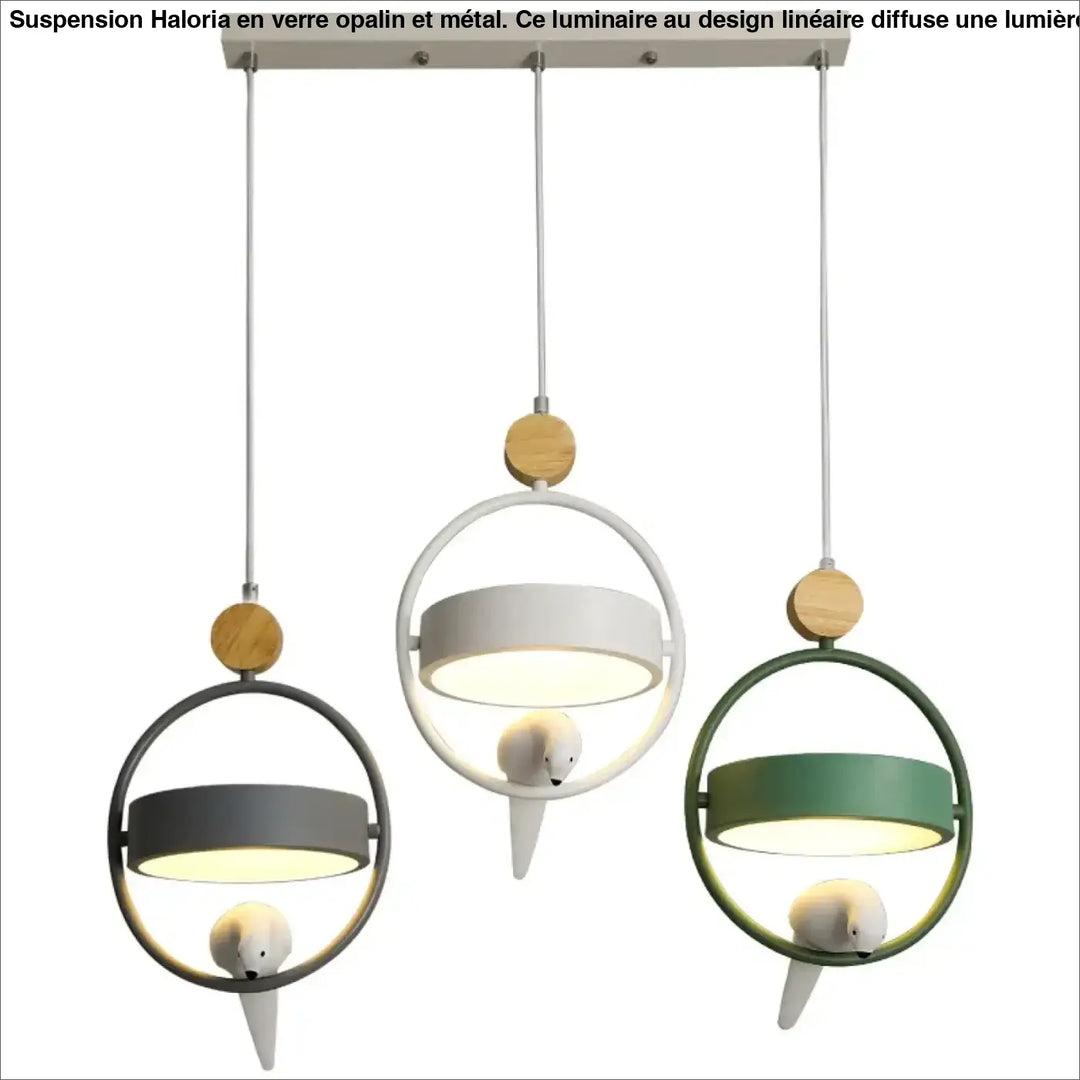 Suspension luminaire lineaire en verre opalin moderne avec cadres metalliques gris, blanc et vert, oiseau en peluche, idéale au-dessus d’un coin salon
