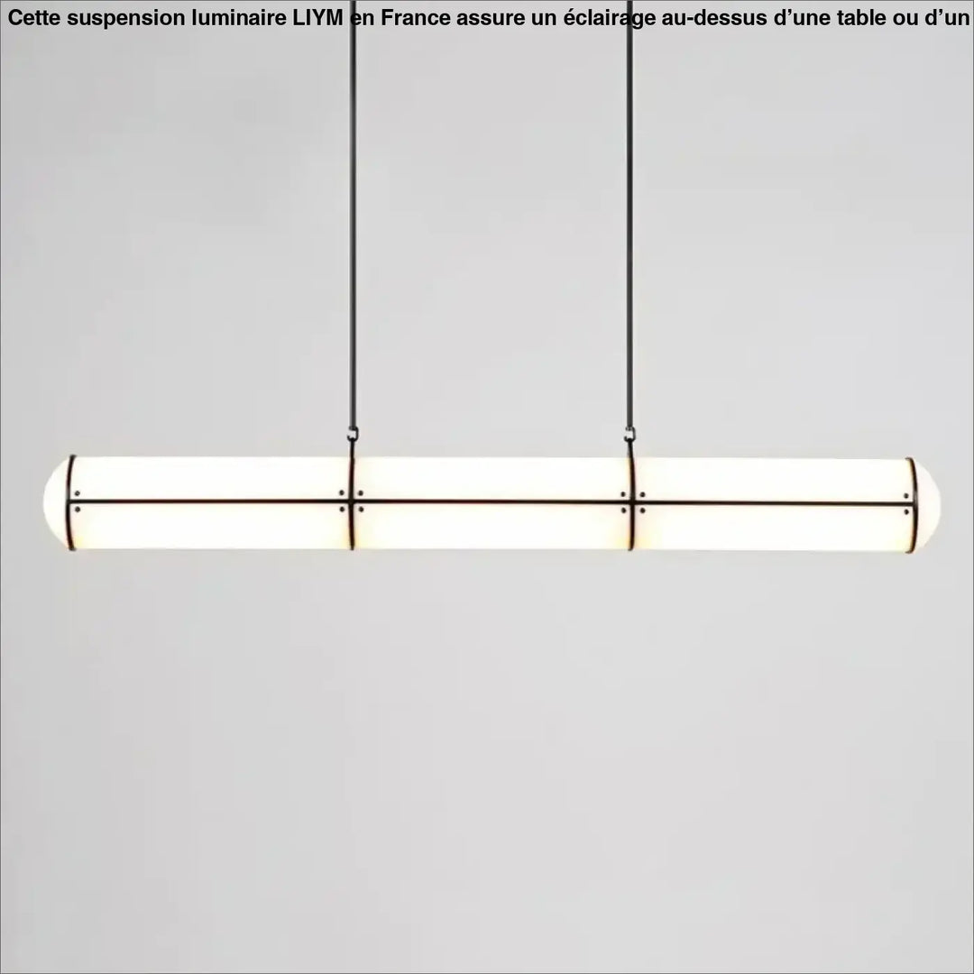 Suspension luminaire moderne avec design cylindrique allongé, verre dépoli et cadre métal noir au-dessus d’une table