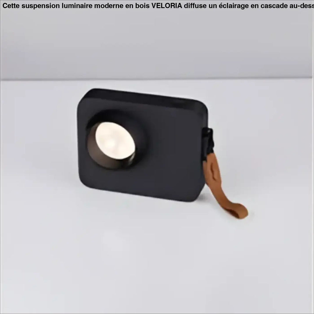 Lampe de table focalis avec faisceau lumineux ciblé, enceinte portable noire, grille blanche circulaire et sangle cuir marron