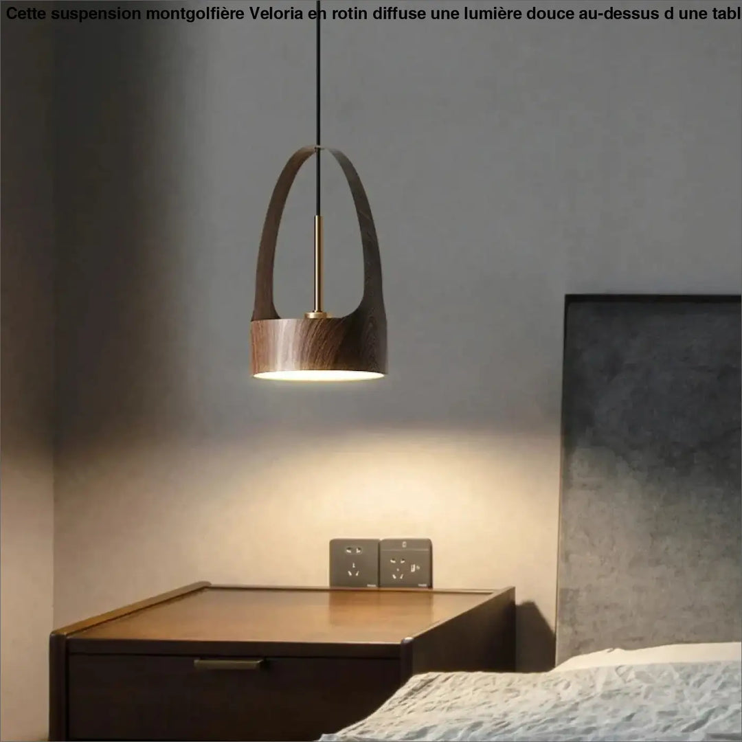 Suspension luminaire montgolfiere design avec panier en rotin veloria au-dessus d’une table en bois foncé avec accents en laiton