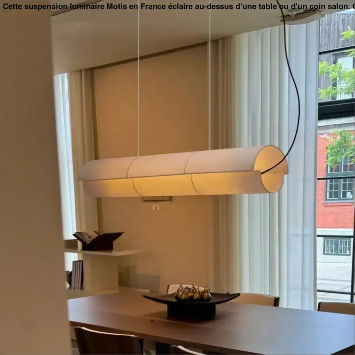 Suspension luminaire motis cylindrique avec abat-jour en tissu beige au-dessus d’une table ou d’un coin salon