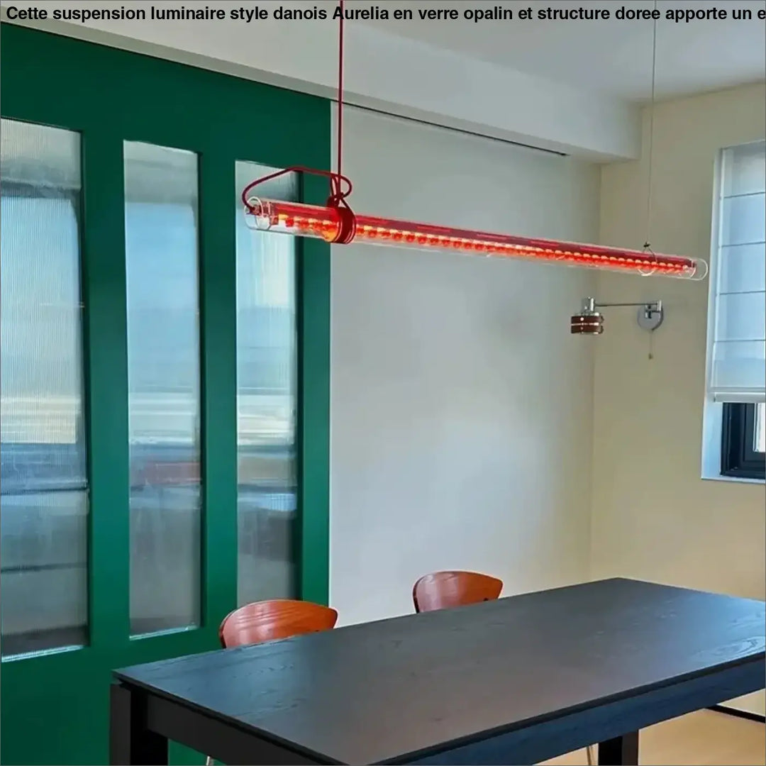 Suspension luminaire nushia en verre soufflé rouge avec led intégrées et câble tressé suspendue au-dessus d’une table à manger