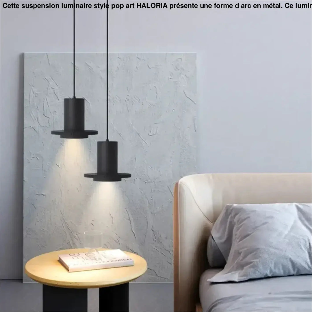 Deux suspensions luminaire danys cylindriques noires avec bases plates en pierre trou noir suspendues au-dessus d’une salle à manger