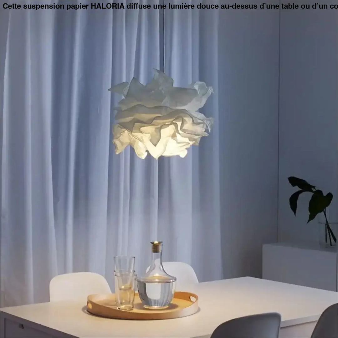 Suspension papier haloria blanche en papier plissé au-dessus d’une table avec un design doux semblable à un nuage