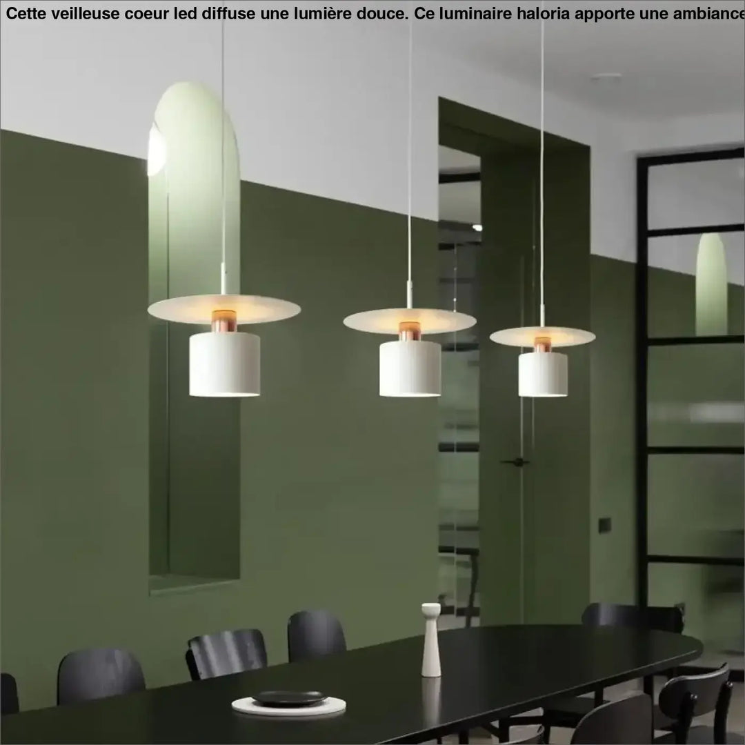 Suspension luminaire bougy avec trois suspensions raffinées en verre incurvé et abat-jour cylindrique blanc au-dessus d’une table sombre