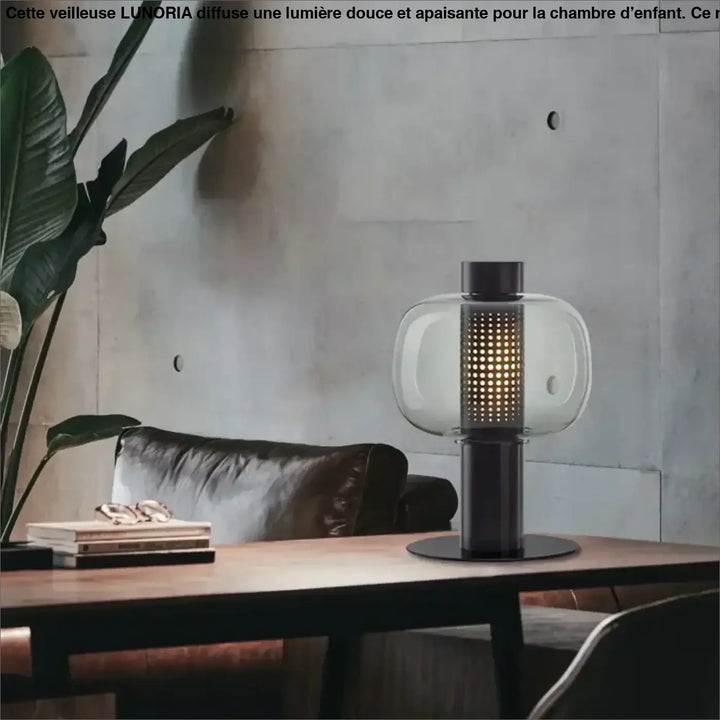 Lampe de table vetra avec globe en verre coloré clair, base en métal noir et colonne perforée lumineuse design moderne