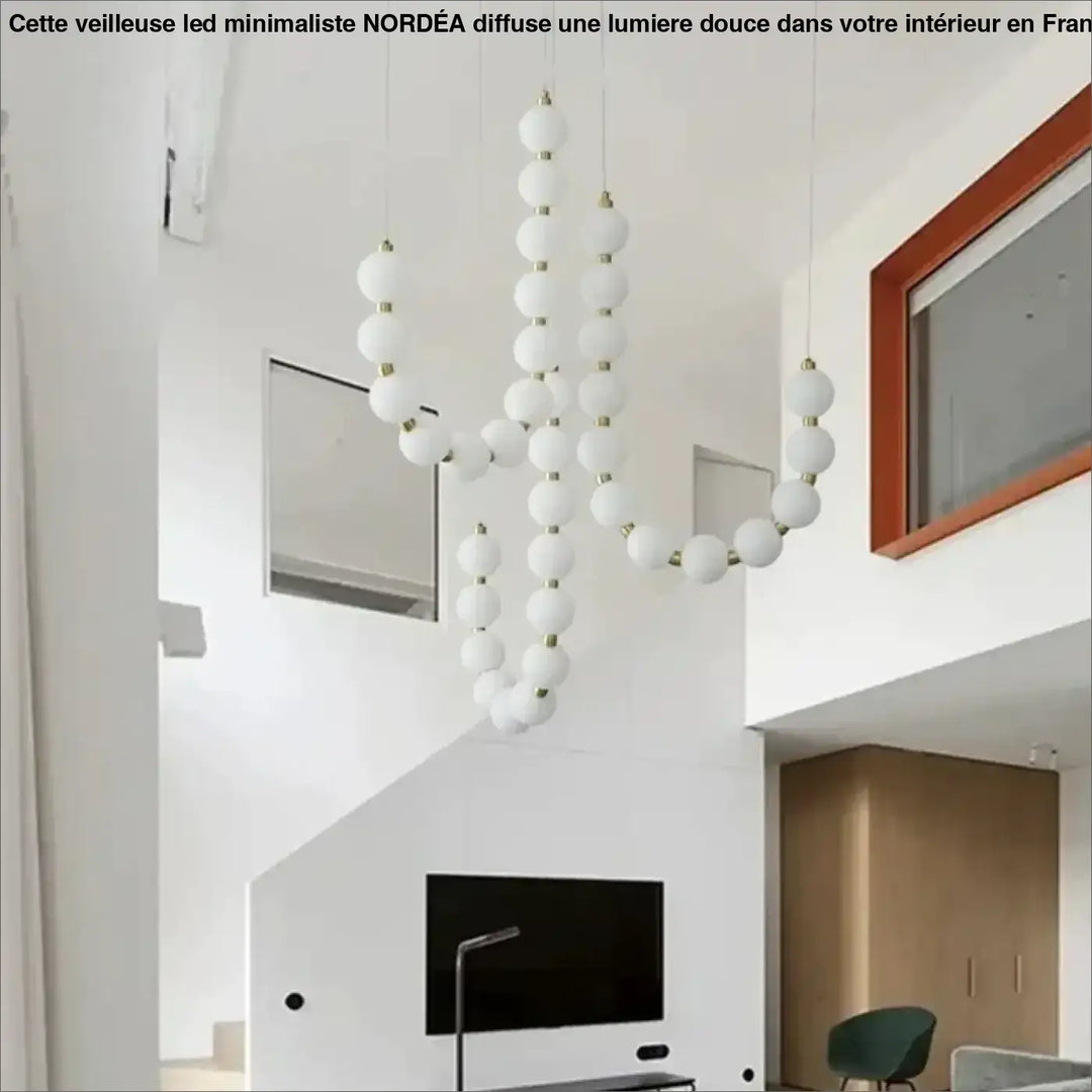 Suspension luminaire perles blanches avec connecteurs dorés offrant une ambiance douce et élégante
